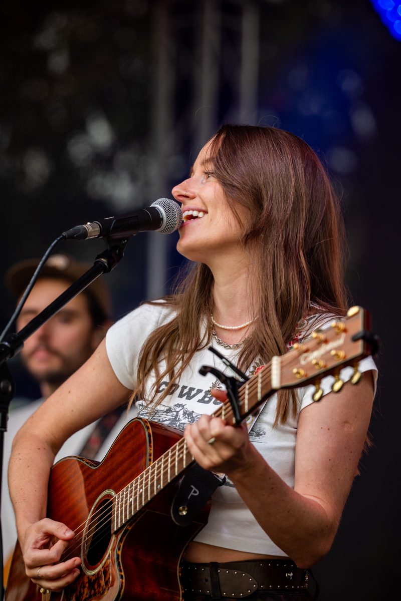 Artist mid-song with her guitar on The Stage at NashDown