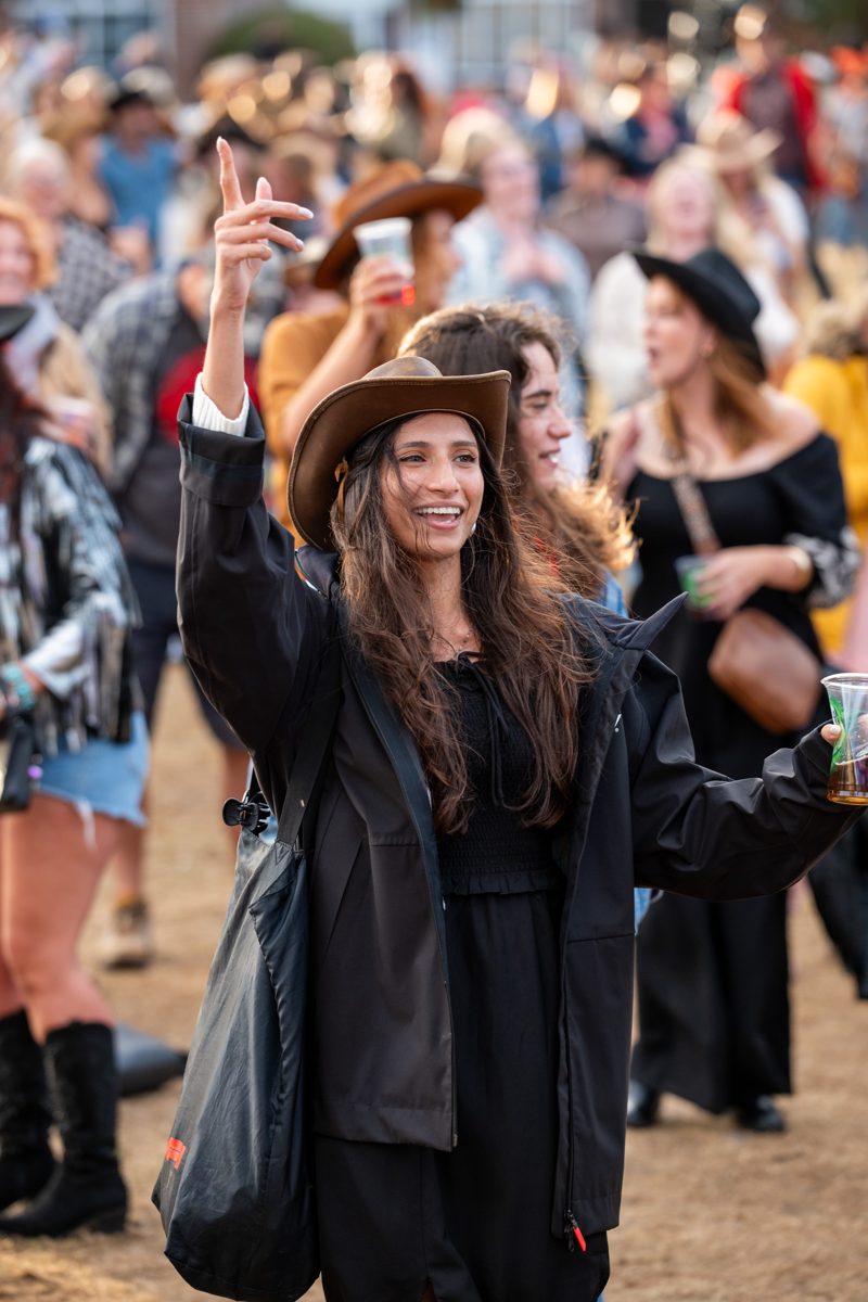 Crowd in cowboy hats with hands in the air